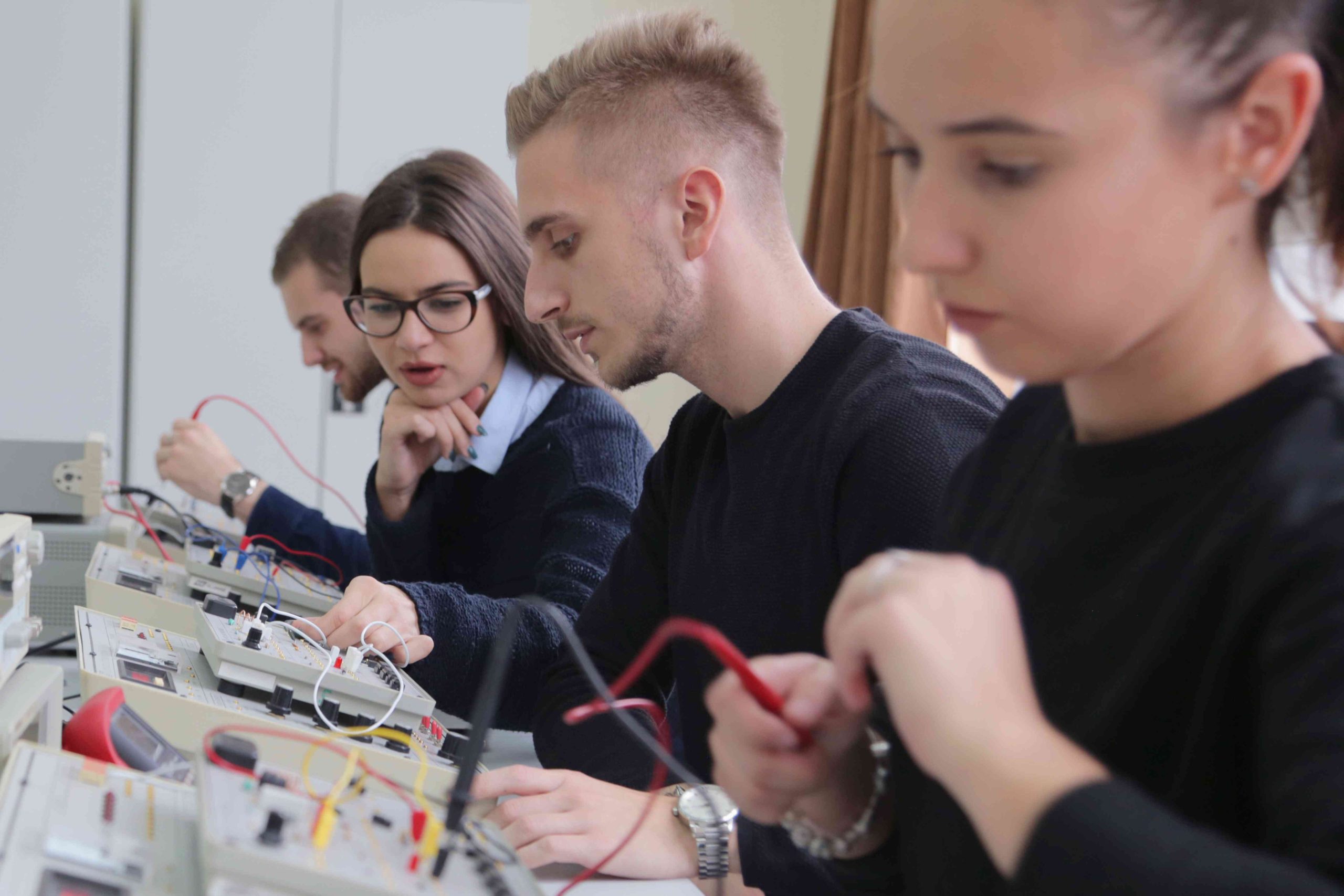 Engineers working together on wiring panels during hands-on training