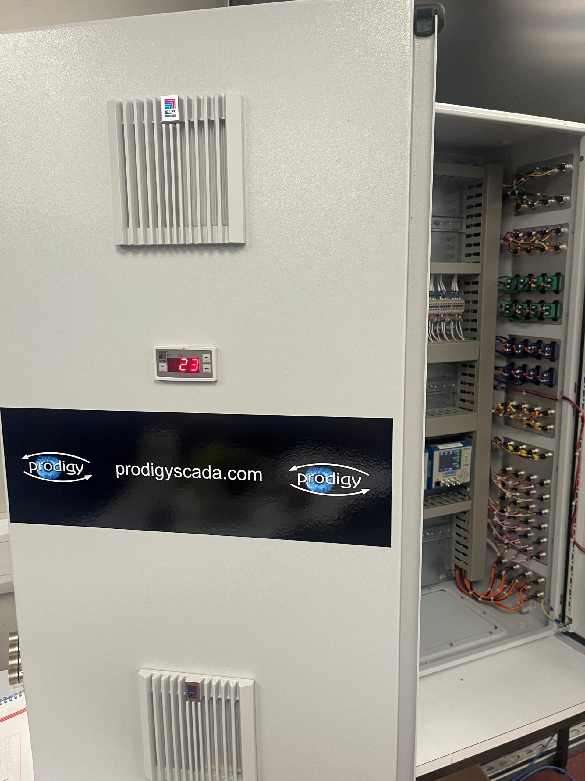 Close-up of an I/O panel with the door open, showing terminals and wiring